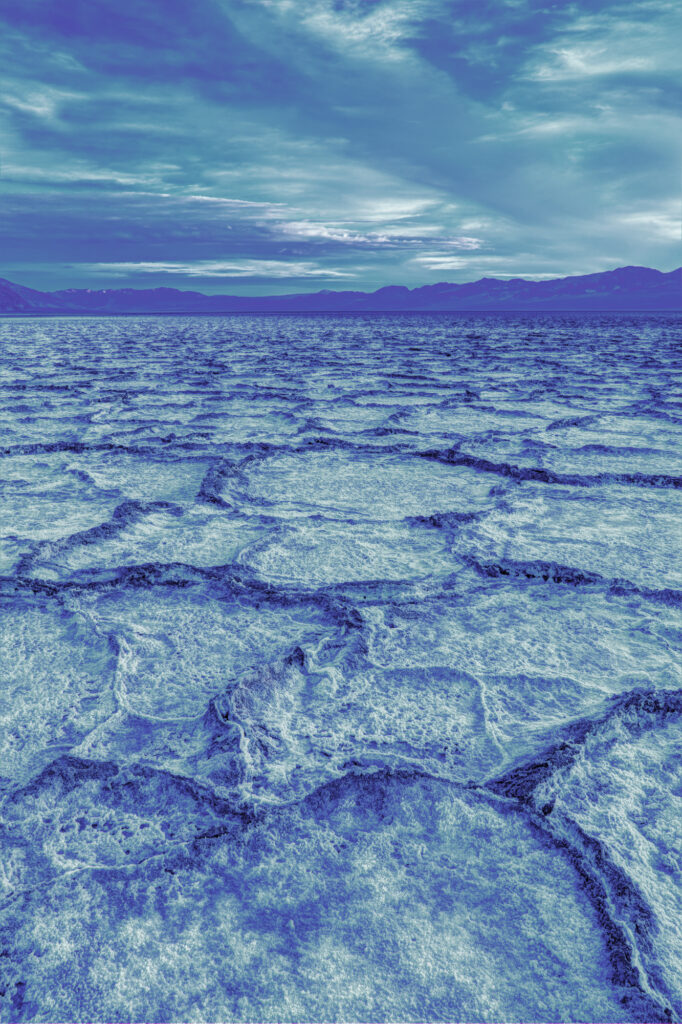 Blue Hour Over The Distant Mountains And Salt Mud Cracks In The Primordial Ooze At Badwater Basin, Death Valley National Park, California